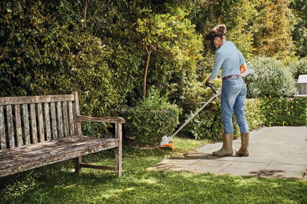 mulher cortando bordas do jardim